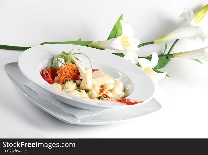 Pasta served with cheese and nicely decorated in a white plate. Pasta served with cheese and nicely decorated in a white plate