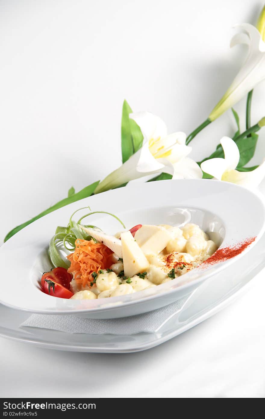 Pasta served with cheese and nicely decorated in a white plate. Pasta served with cheese and nicely decorated in a white plate