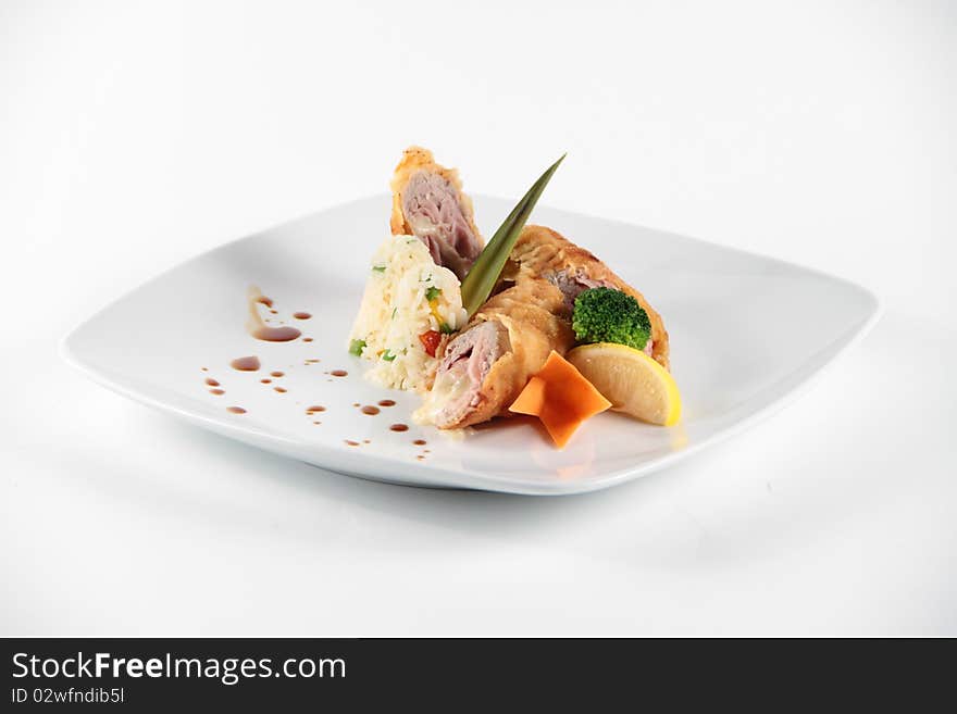 Meat rolls served and decorated with vegeables on a white plate. Meat rolls served and decorated with vegeables on a white plate