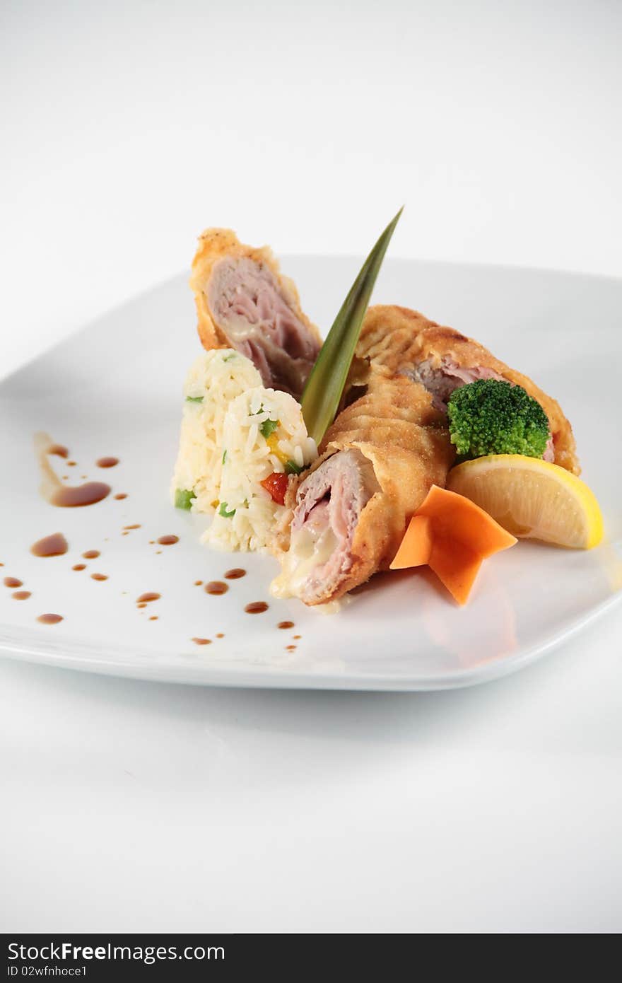 Meat rolls served and decorated with vegeables on a white plate. Meat rolls served and decorated with vegeables on a white plate