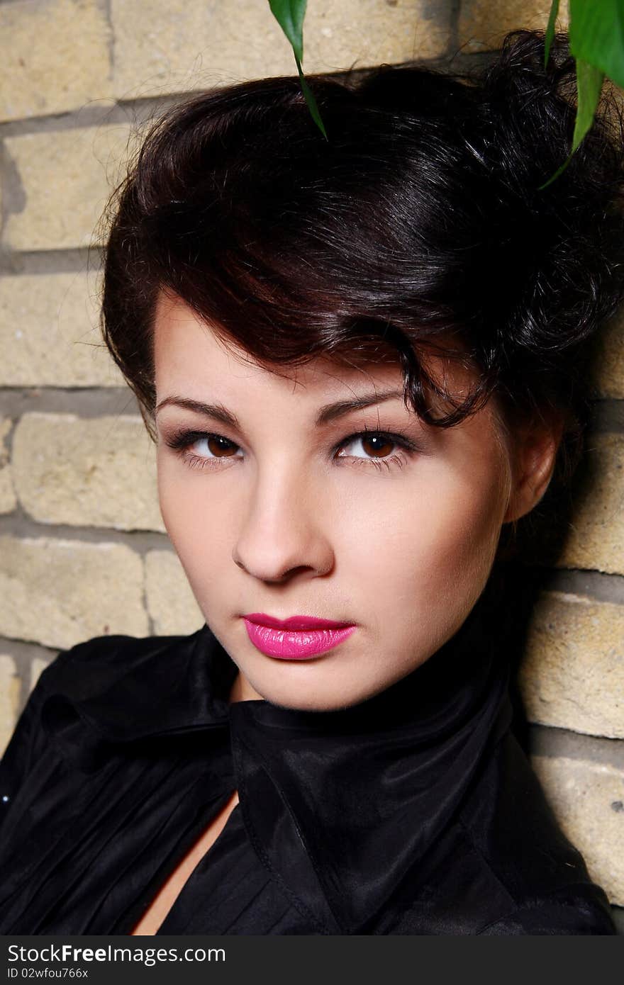 Young and attractive lady beside with brick wall, overgrown of vine leaves