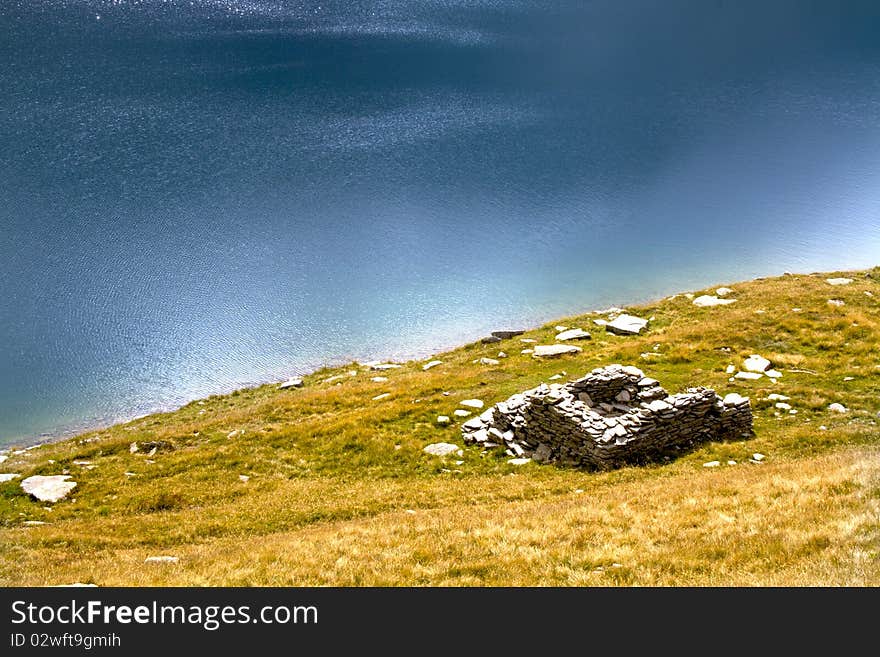 Mountain lake with ruins of a house