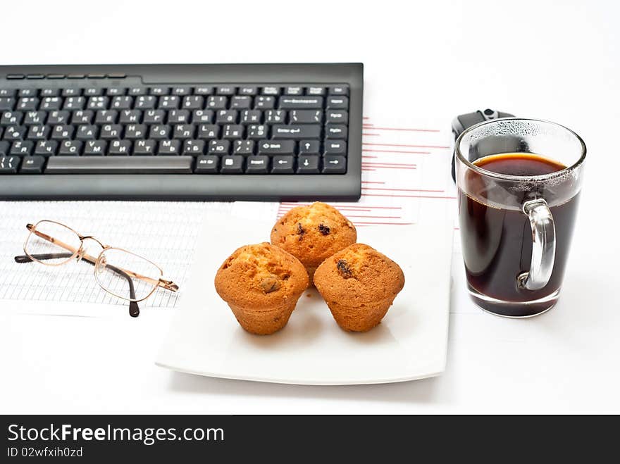 Business still-life with diagrams, glasses, coffee, cakes on plate and keyboard. Business still-life with diagrams, glasses, coffee, cakes on plate and keyboard