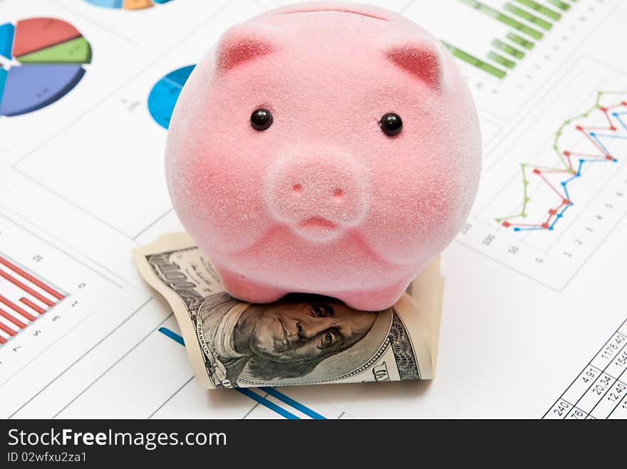 Piggy bank on money with business charts. Piggy bank on money with business charts