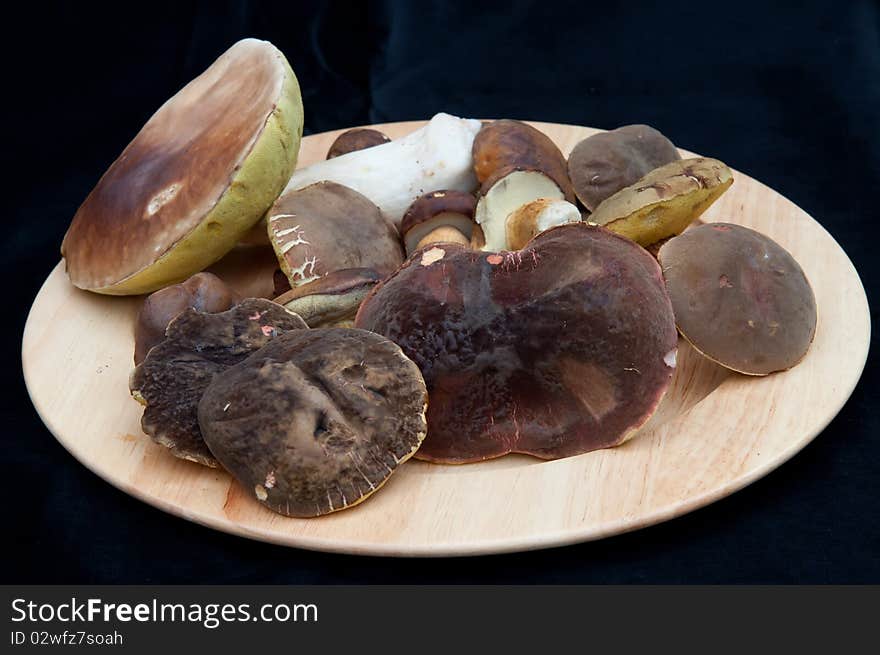 Mushrooms on the plate and black background. Mushrooms on the plate and black background.