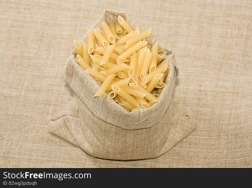 Burlap sack  full with raw  macaroni