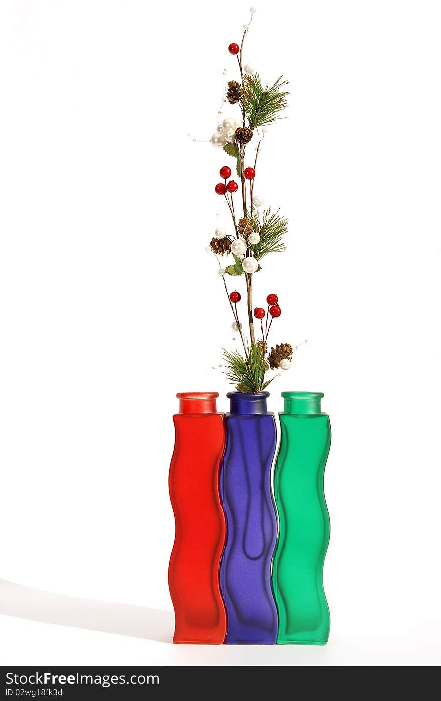 Christmas decoration in colored glass vase on white background