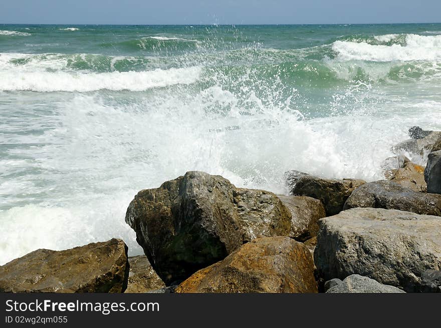 Waves crashing over the rocks in the surf at New Smyrna Beach, Florida. Waves crashing over the rocks in the surf at New Smyrna Beach, Florida.