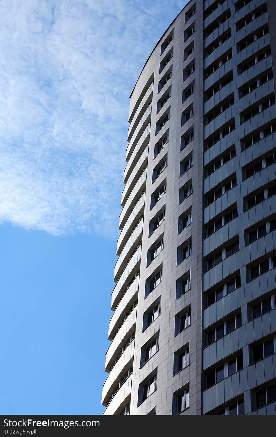 Closeup of high modern building on blue sky background