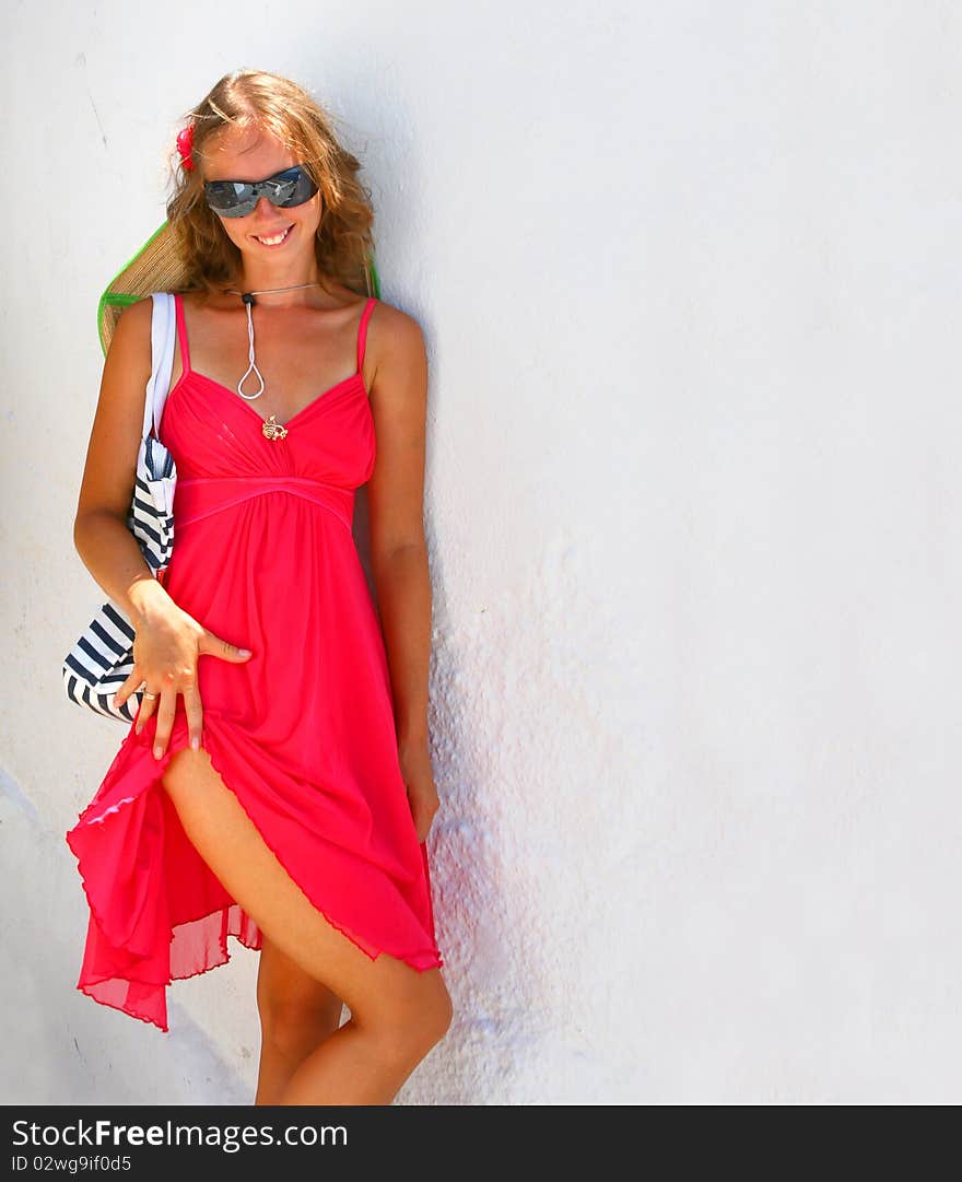 Sweet lady in red on a beautiful white background in Santorini, Greece
