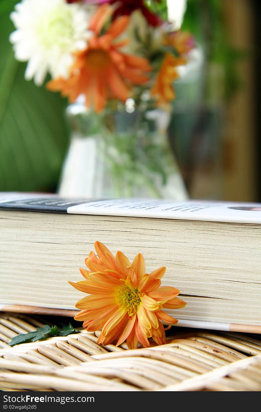 Closed book on a table with flowers