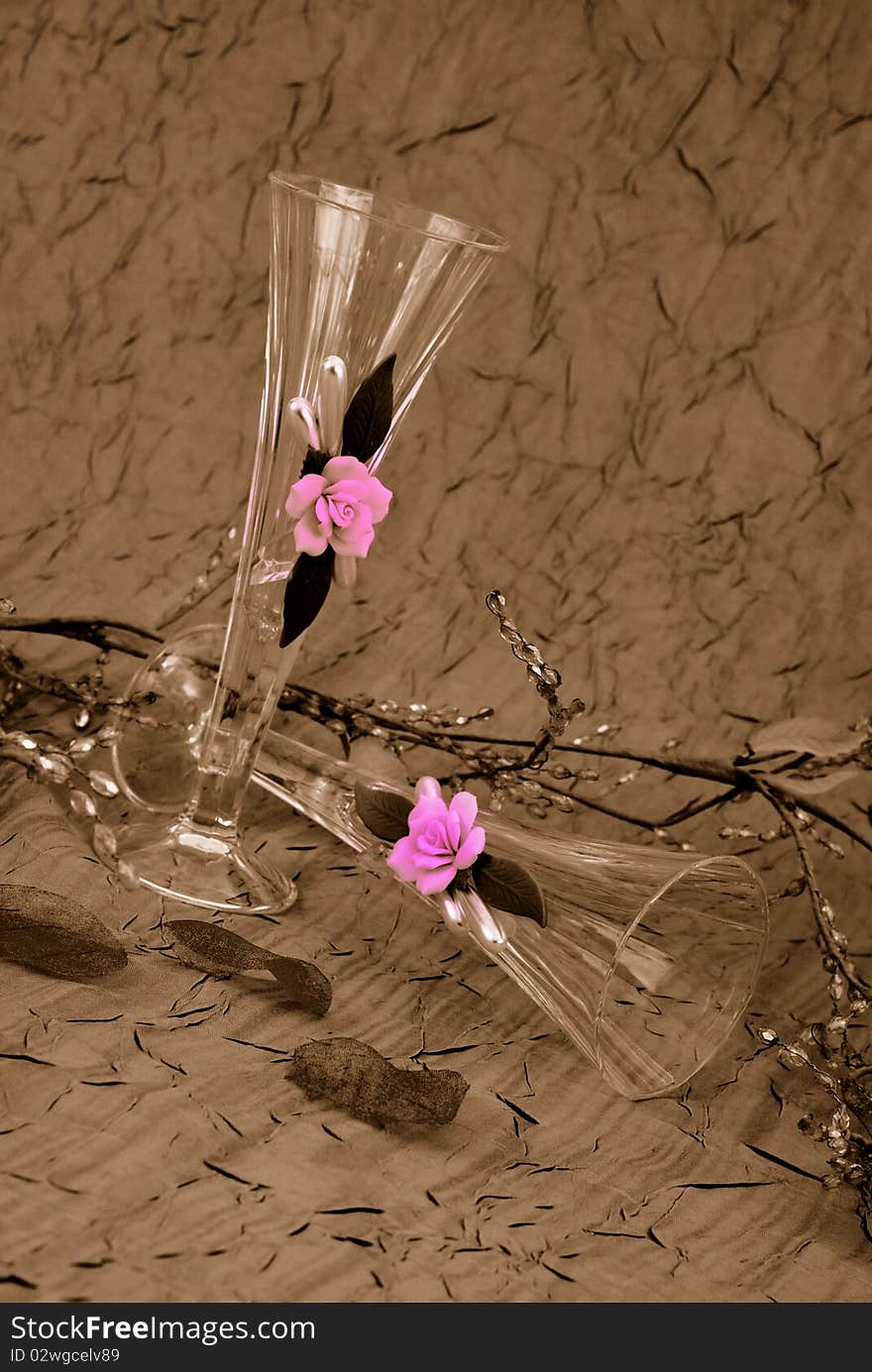 Champagne glasses on sepia with pink roses on the glass. Champagne glasses on sepia with pink roses on the glass