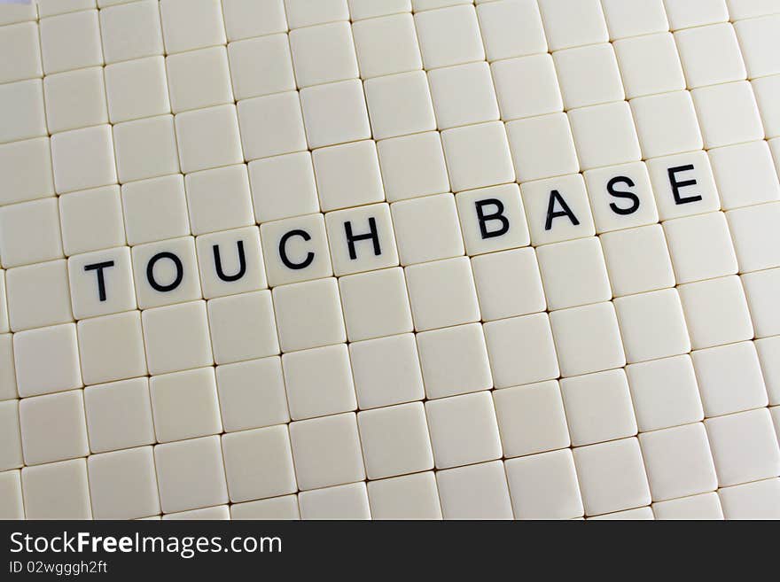 The words 'touch base' spelled out in tiles with blank tiles around them.