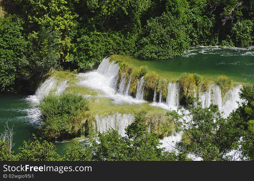 View of the waterfall surrounded by trees from the top of