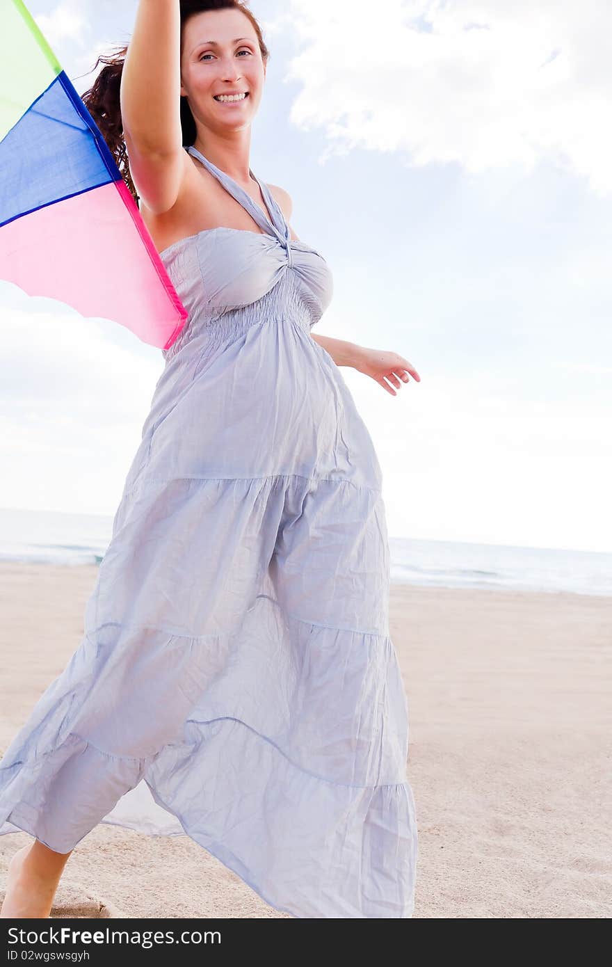 Smiling happy healthy woman walking on beach with kite in winter autumn spring time. Smiling happy healthy woman walking on beach with kite in winter autumn spring time