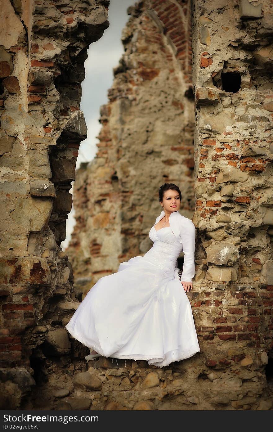 Bride sitting on ruins