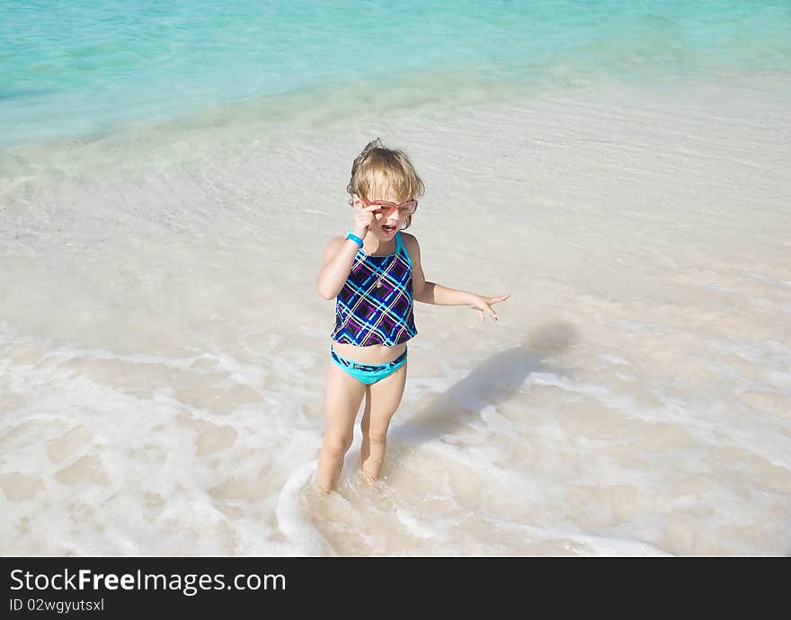 Little girl playing in sea on the Aruba's beach in summer day. Little girl playing in sea on the Aruba's beach in summer day.