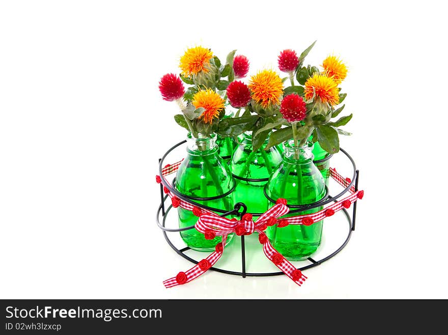 Orange and red flowers in five glass vases in green liquid water