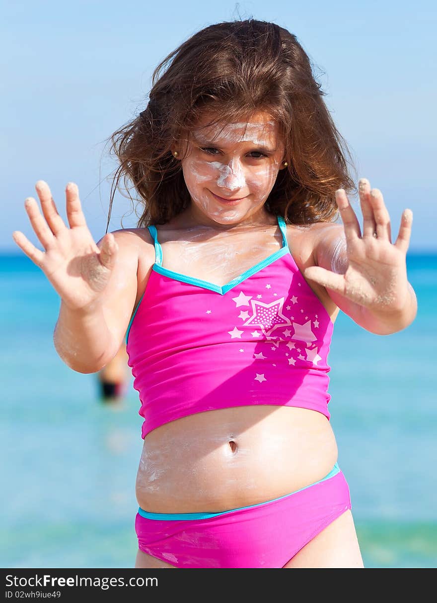 Girl On A Tropical Beach With Sun Cream