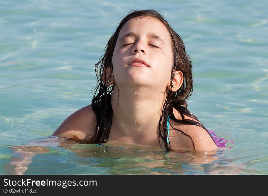 Girl on a swimming suit sitting in the beach