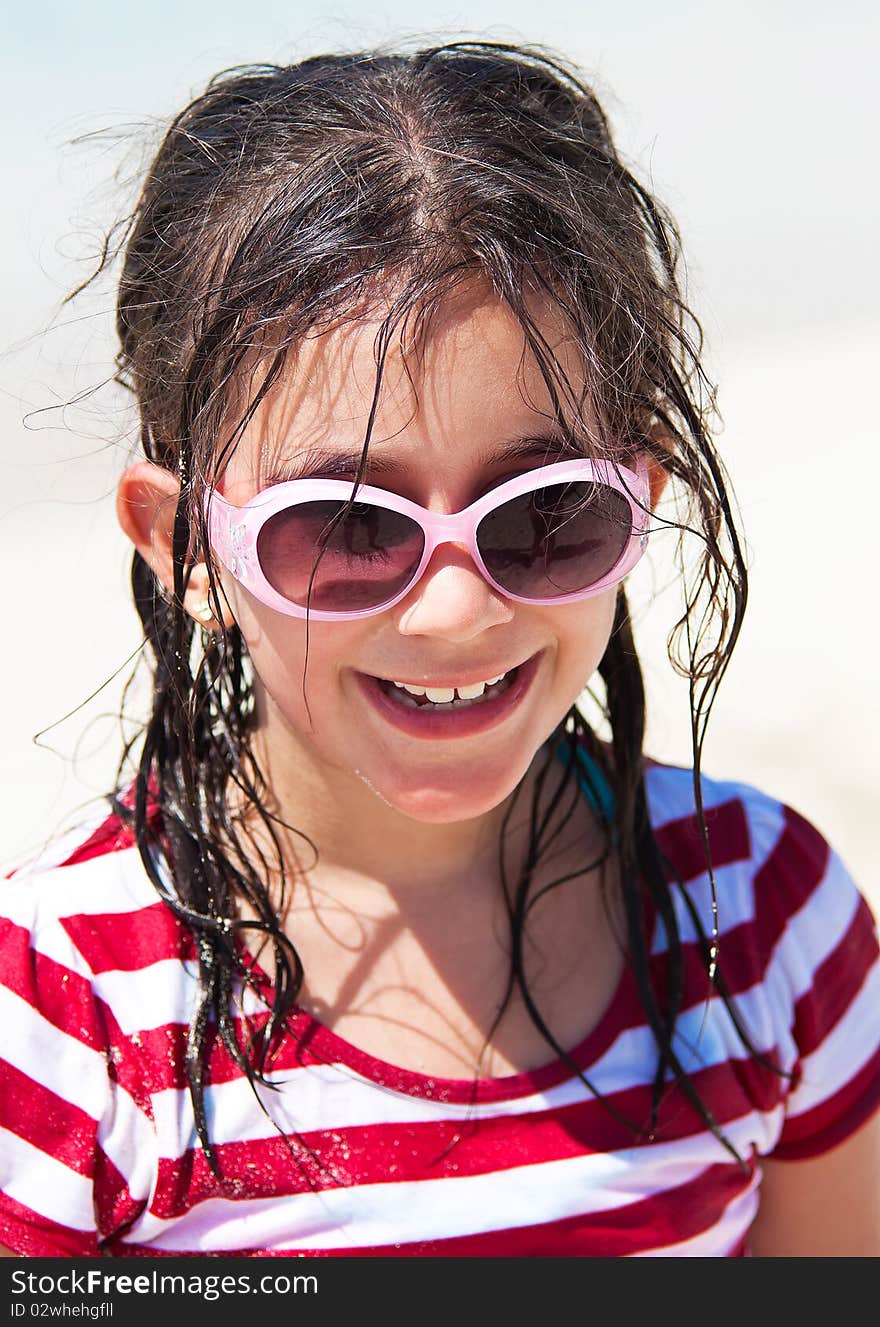 Beautiful girl with sunglasses and messy hair smiling at the camera. Beautiful girl with sunglasses and messy hair smiling at the camera