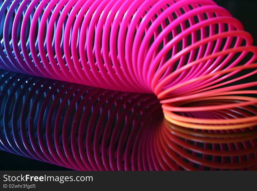 Colored spiral made of plastic over black background. Colored spiral made of plastic over black background