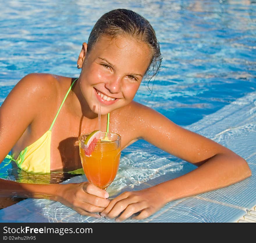 Cute girl with a cocktail at pool