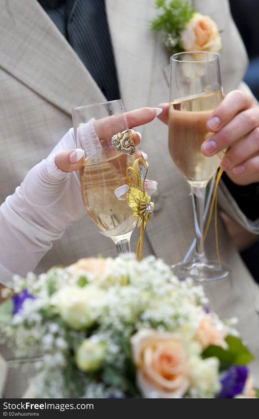 Bride and groom are holding champagne glasses