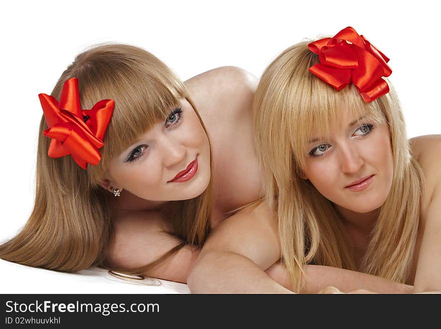 Portrait of two smiling young women with gift red bow over white background