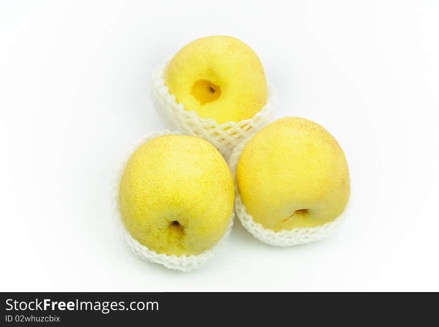 Nashi Pears in shipping net on a white surface.