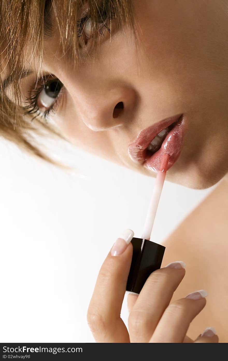 Woman applying liquid glossy lipstick