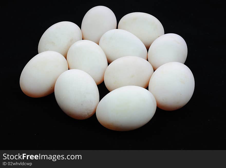 White eggs on black background.