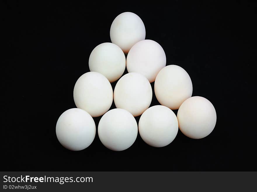 White eggs on black background.