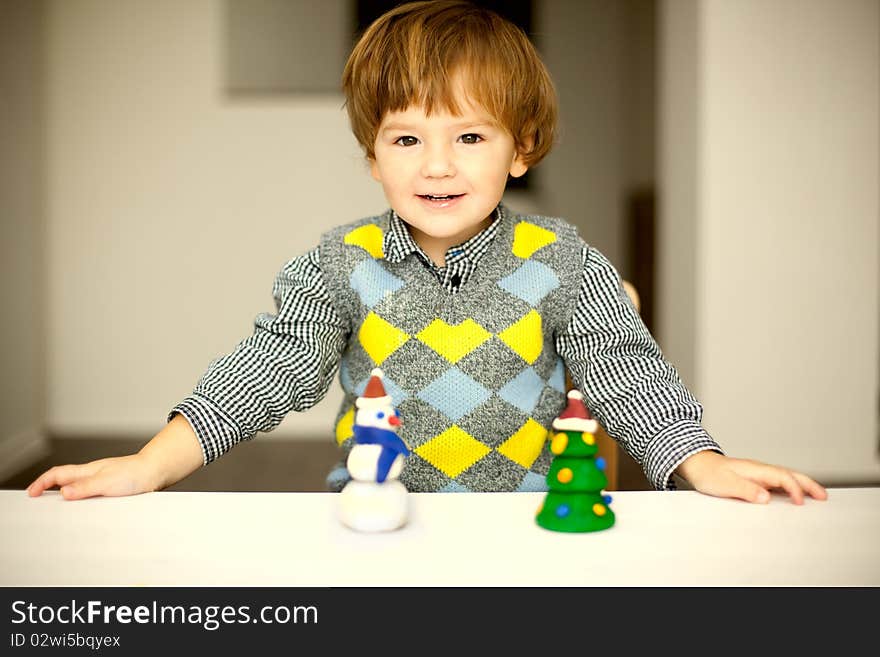 A child making a snowman and christmas tree of plasticine. A child making a snowman and christmas tree of plasticine