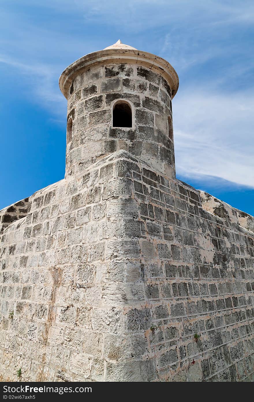 Tower and walls of an old castle with a beautiful blue sky background. Tower and walls of an old castle with a beautiful blue sky background