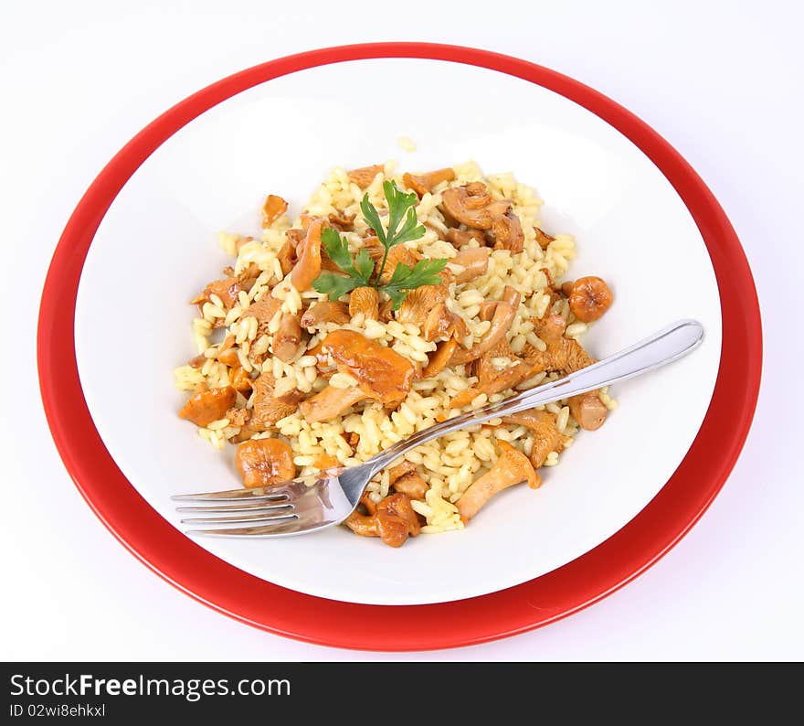 Risotto with mushrooms on a plate decorated with parsley and a fork