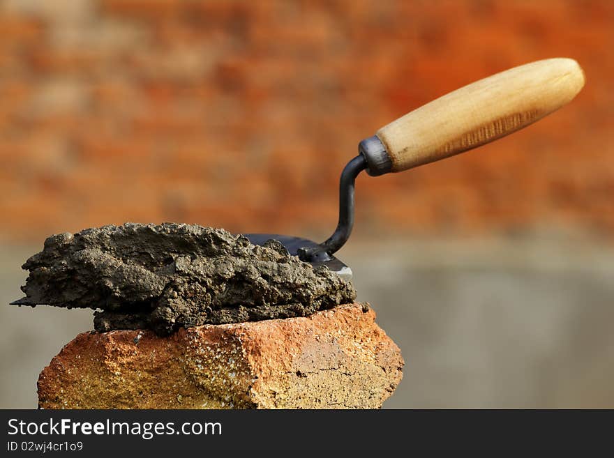 The tool a shovel with concrete on a brick. The tool a shovel with concrete on a brick