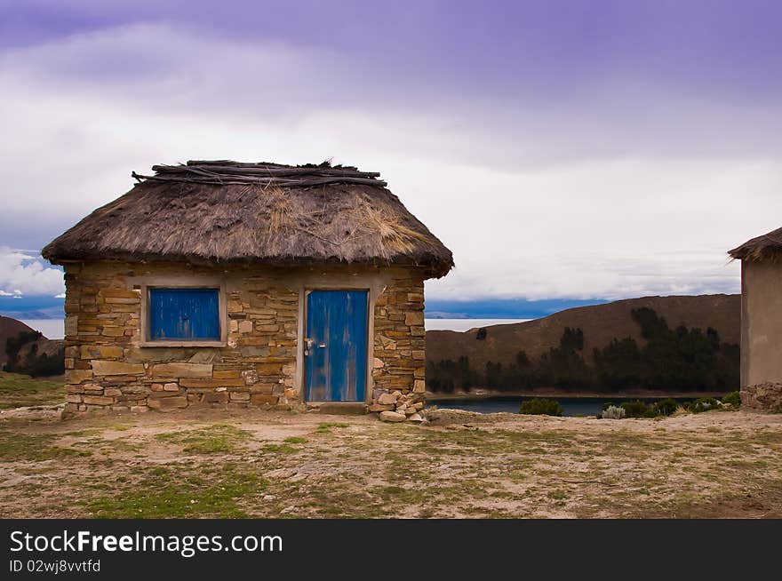 Stone and thatch hut which is located on an island, Isla del Sol, on the Bolivian side of Lake Titicaca. Stone and thatch hut which is located on an island, Isla del Sol, on the Bolivian side of Lake Titicaca.