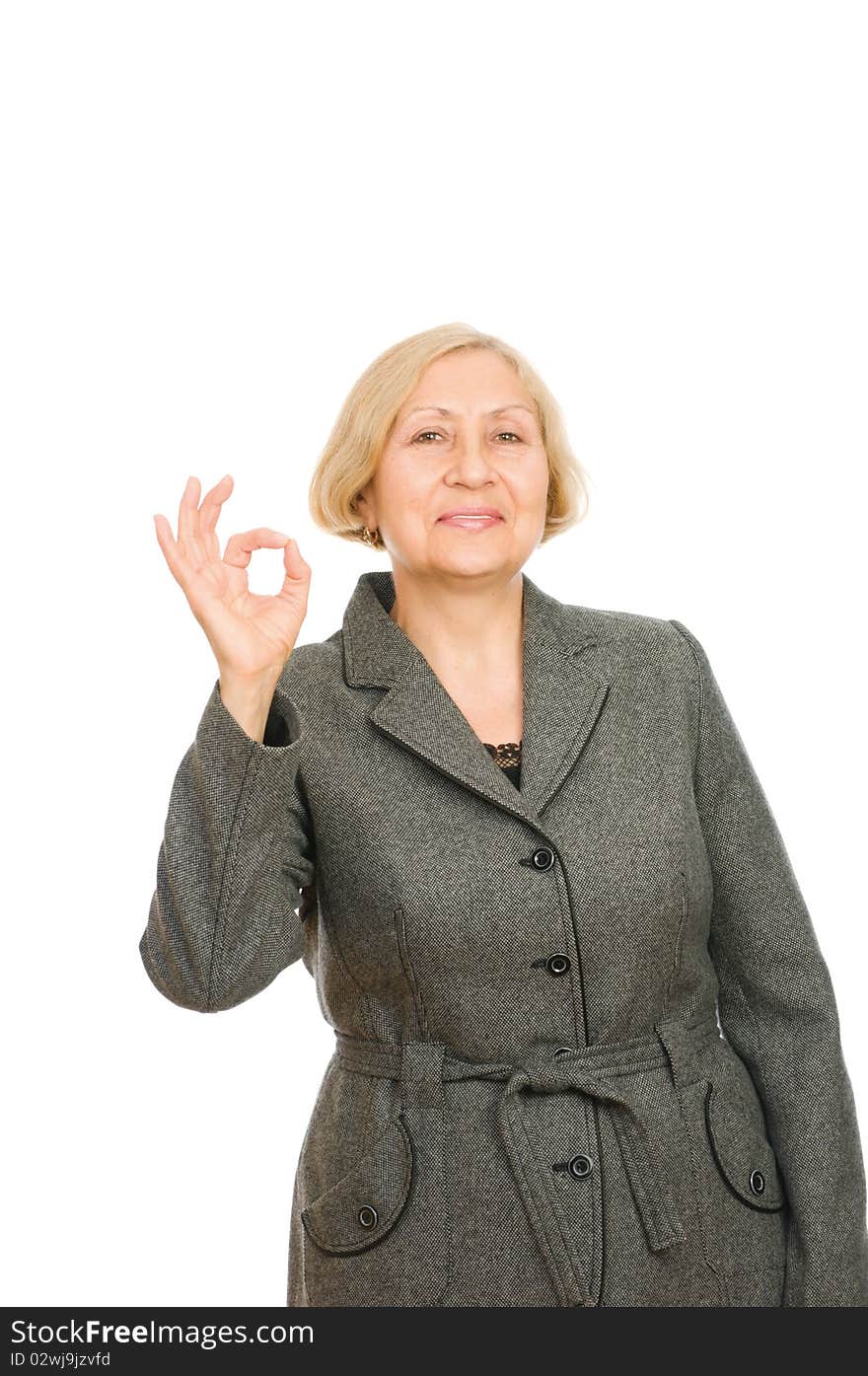 Portrait of a smiling senior business woman showing okay symbol isolated on white background