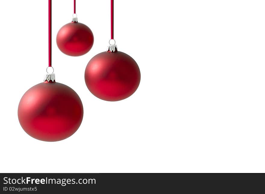 Christmas balls hanging on reds ribbons over a white background background