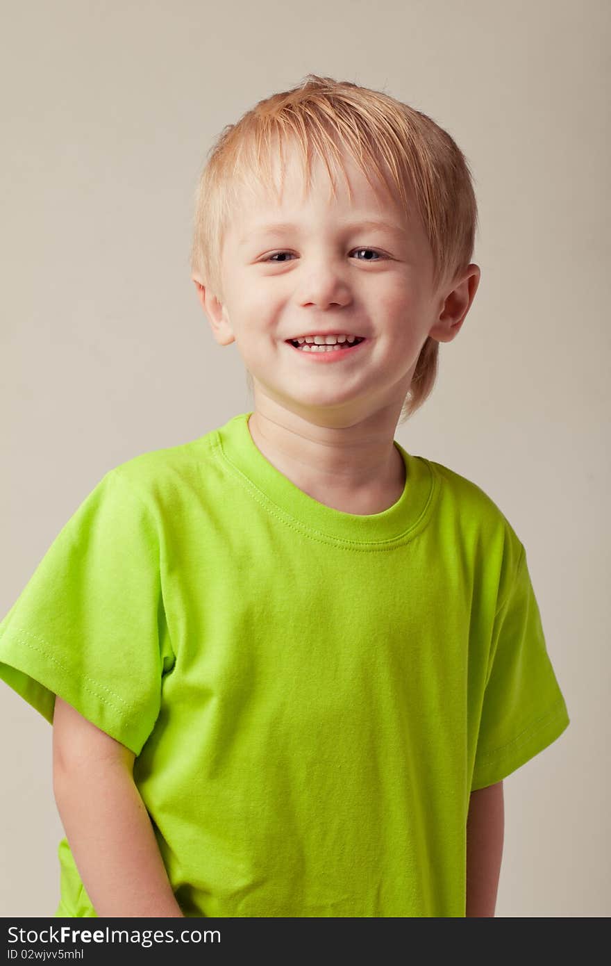 Boy smiles on a gray background. Boy smiles on a gray background