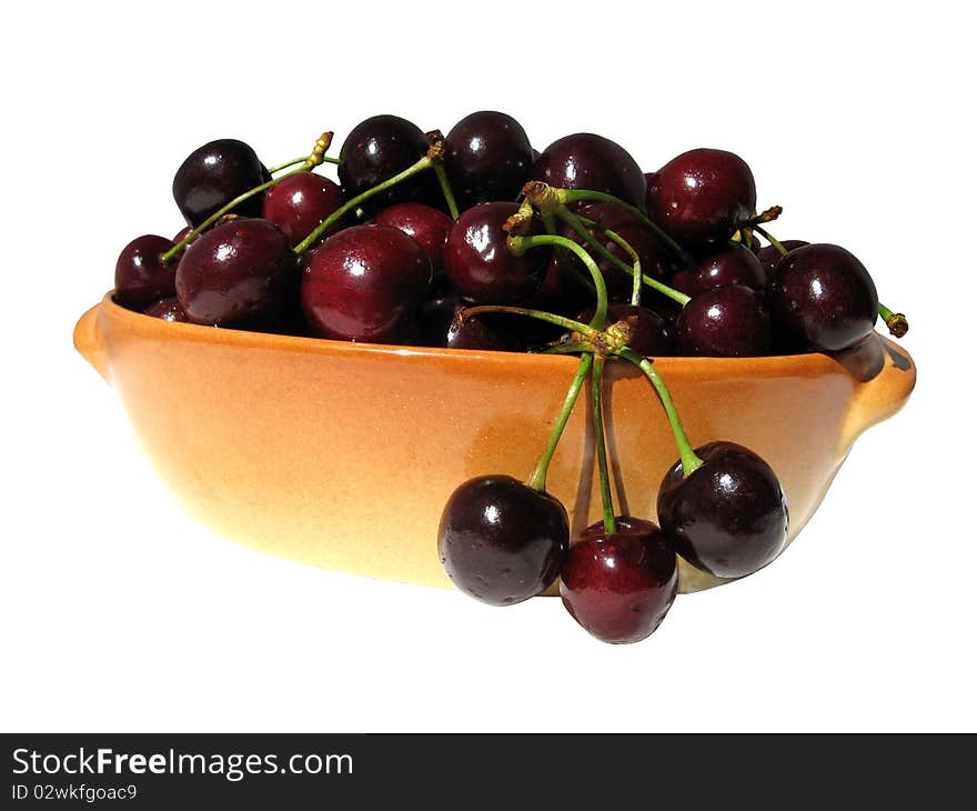 Ripe sweet cherries in the oval buff ceramic dish isolated on white