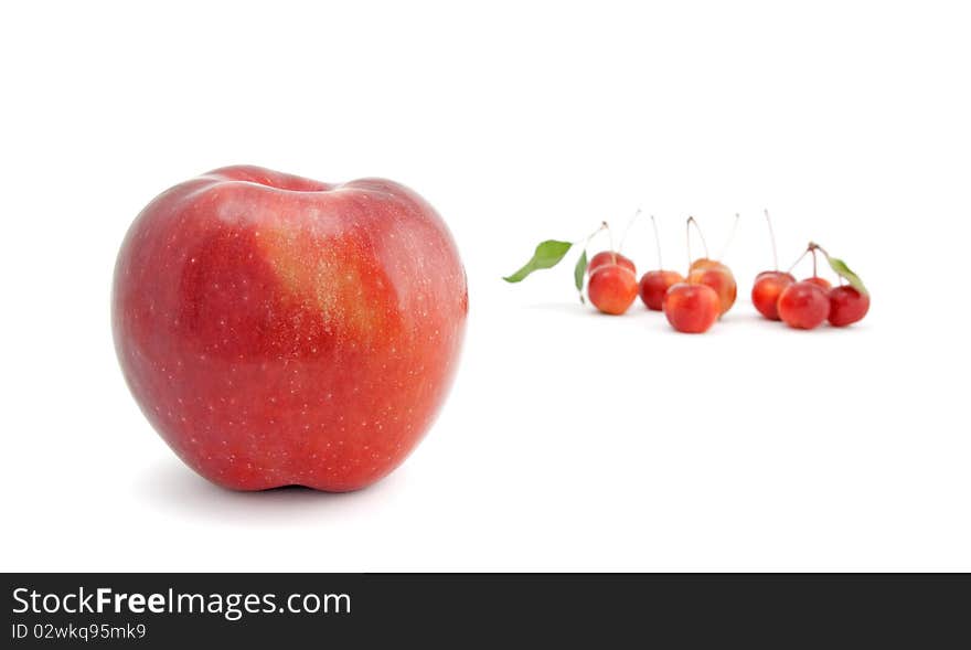 Big red apple with small Chinese cherry apples in the background, isolated on white. Big red apple with small Chinese cherry apples in the background, isolated on white.