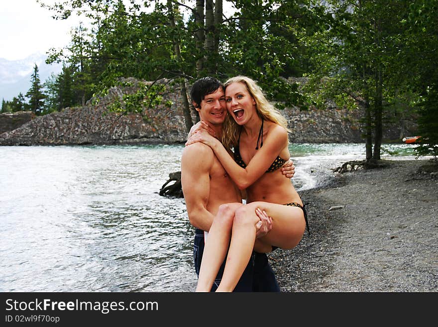 Man holding woman in swim suits. Man holding woman in swim suits