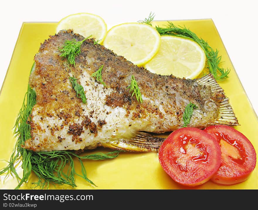 Grilled river fish with vegetables on yellow plate. Grilled river fish with vegetables on yellow plate