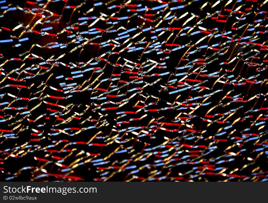 Colored Reflections of Cracks in Broken Glass with Black Background. Colored Reflections of Cracks in Broken Glass with Black Background