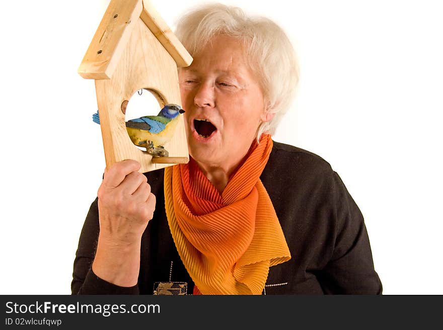 Senior woman is speaking with a bird. Senior woman is speaking with a bird