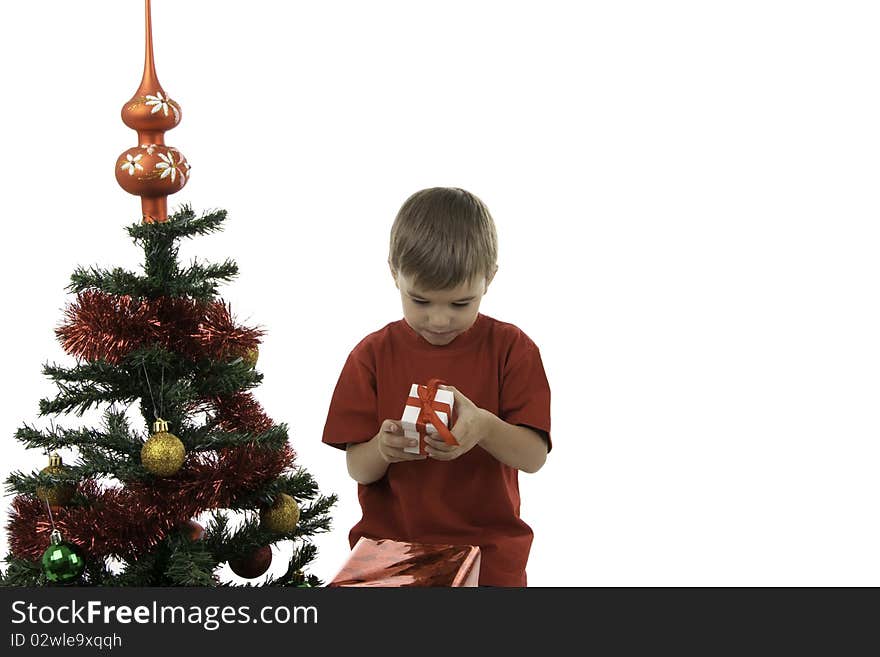 The boy with gifts near to a New Year tree. The boy with gifts near to a New Year tree