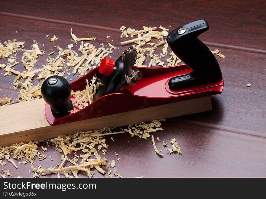 Red plane on brick and shavings.