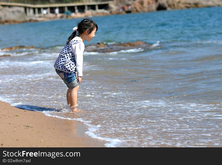 A Lovely Chinese girl，who is playing on the beach